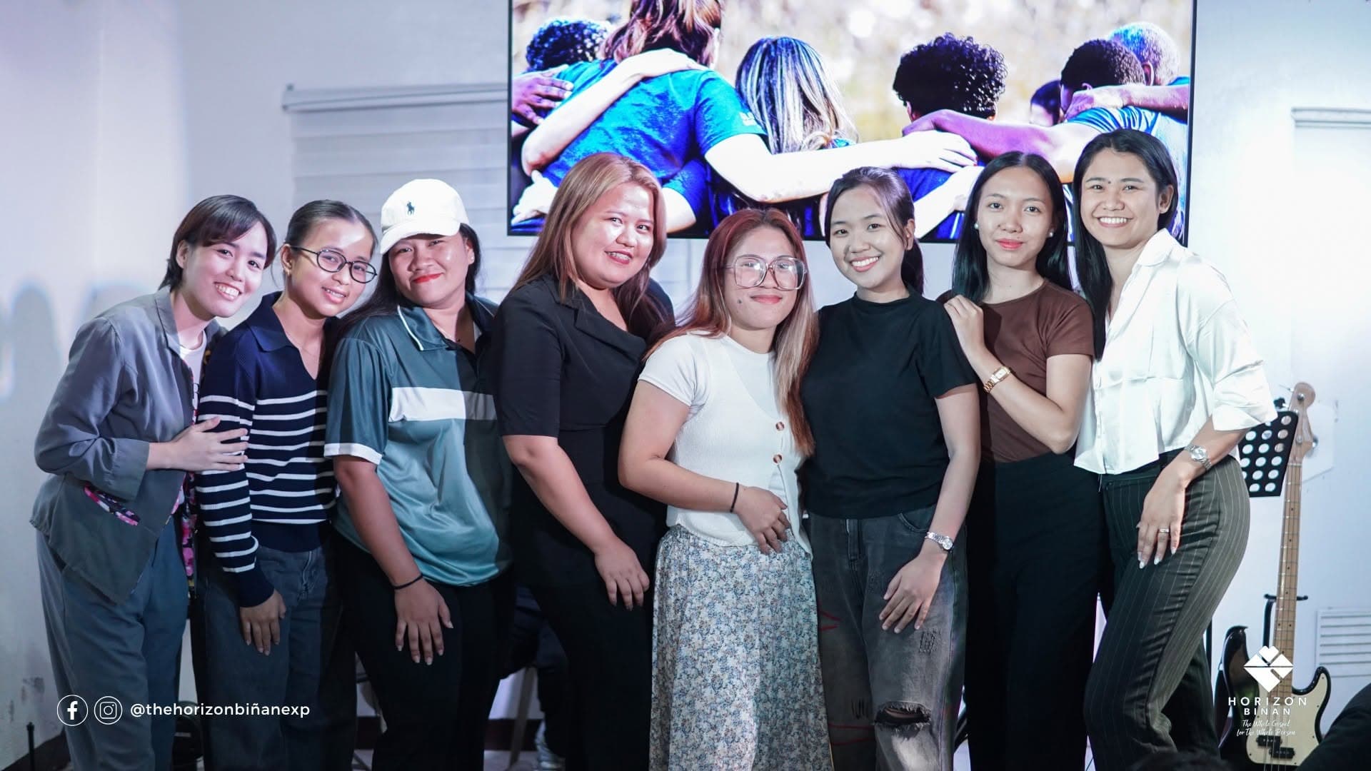 Smiling women of the Horizon Biñan church family standing together at the front of the hall.